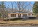 Lovely single-story home with a wooden deck, situated on a well-kept lawn with mature trees at 409 Katherine Ln, Woodstock, GA 30189