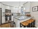 Bright eat-in kitchen with white cabinets, stainless steel appliances, and granite countertops at 409 Katherine Ln, Woodstock, GA 30189
