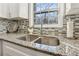 Close up view of a stainless steel sink with granite countertops and a neutral backsplash at 409 Katherine Ln, Woodstock, GA 30189