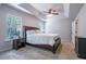 Well-lit bedroom with large bed, ceiling fan, and windows offering view of the exterior at 120 Park Village Dr, Canton, GA 30114