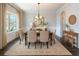 Formal dining room featuring wainscoting, wood floors, and elegant chandelier and ample natural light at 120 Park Village Dr, Canton, GA 30114