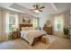 Serene primary bedroom featuring a tray ceiling, soft lighting, and large windows at 120 Park Village Dr, Canton, GA 30114