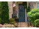 Charming brick home featuring a covered front door with black iron railings and manicured landscaping at 14 Lochurst Ln # 15, Roswell, GA 30076