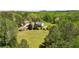 Expansive estate featuring a brick home, guest house, and ample green space surrounded by lush trees at 190 Ward Rd, Ellenwood, GA 30294