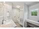 Bright bathroom featuring a shower over tub, a large window, and marble countertops at 190 Ward Rd, Ellenwood, GA 30294