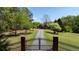 Gated entrance leads to a charming property with a long driveway and mature landscaping at 190 Ward Rd, Ellenwood, GA 30294