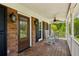 Charming brick home featuring a covered front porch with rocking chairs and a ceiling fan at 190 Ward Rd, Ellenwood, GA 30294