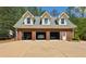 Brick three-car garage exterior with white trim and dormer windows, offering ample parking and storage at 190 Ward Rd, Ellenwood, GA 30294