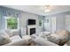 Bright living room with plush seating, a fireplace, and natural light from multiple windows at 190 Ward Rd, Ellenwood, GA 30294