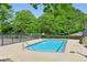 Community pool surrounded by a fence and green trees at 285 Lakemoore Ne Dr # A, Atlanta, GA 30342