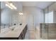 Well-lit primary bathroom with double vanity, soaking tub, glass enclosed shower and neutral tile at 3049 Ivy Crossing Dr, Buford, GA 30519