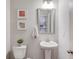 Charming powder room with a pedestal sink, decorative mirror and soft grey paint at 3049 Ivy Crossing Dr, Buford, GA 30519