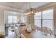 Bright dining area with hardwood floors, modern lighting, and a view into the living room at 3049 Ivy Crossing Dr, Buford, GA 30519