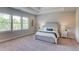 Spacious main bedroom with tray ceiling, plush carpet, and sun-filled windows with verdant outdoor views at 3049 Ivy Crossing Dr, Buford, GA 30519