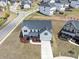 This aerial shot shows a beautiful two-story home with a well-manicured front yard, a paved driveway, and lovely landscaping at 4890 Revere Way, Cumming, GA 30028