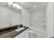 Bathroom with a granite countertop, white cabinets, and a white bathtub and shower at 4890 Revere Way, Cumming, GA 30028