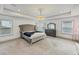 Bright bedroom with a chandelier, tufted headboard, and carpet at 4890 Revere Way, Cumming, GA 30028
