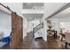 Inviting entryway with hardwood floors, barn door, staircase, and open access to the living and dining areas at 4890 Revere Way, Cumming, GA 30028