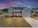 Charming two-story home features a welcoming front porch, well-manicured lawn, and an attached two-car garage at 4890 Revere Way, Cumming, GA 30028