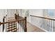 Hallway with brown wooden railing and black iron spindles overlooking the floor below at 4890 Revere Way, Cumming, GA 30028