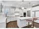 Stylish white kitchen features a central island, modern appliances, and elegant pendant lighting at 4890 Revere Way, Cumming, GA 30028