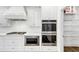 Modern kitchen with stainless steel appliances, white cabinets, and an adjacent pantry at 4890 Revere Way, Cumming, GA 30028