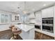 Modern kitchen with white cabinets, island with seating, and stainless steel appliances at 4890 Revere Way, Cumming, GA 30028