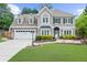 Charming two-story home featuring manicured lawn, a two-car garage, and a welcoming stone pathway to the front door at 230 Bristolstone Ct, Alpharetta, GA 30005