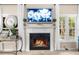 Living room highlighting a fireplace with white mantle, a TV, windows, and a decorative clock on the side table at 230 Bristolstone Ct, Alpharetta, GA 30005