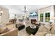 Spacious living room boasts a fireplace, tv, couches, ottomans, chandeliers, and seamless transition to other living spaces at 230 Bristolstone Ct, Alpharetta, GA 30005
