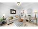 Bright living room featuring neutral paint, modern decor, couch, lamps, and a decorative wooden table at 230 Bristolstone Ct, Alpharetta, GA 30005