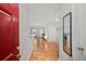 Bright foyer featuring hardwood floors, a red front door, a large mirror, and an open view into the living area at 2700 Pine Tree Ne Rd # 1214, Atlanta, GA 30324