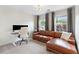 Cozy living room with a brown leather sectional sofa, desk and two large windows at 3303 Timbercreek Cir, Roswell, GA 30076