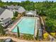 Aerial view of a large community pool with lounge chairs, surrounded by lush landscaping and trees at 3303 Timbercreek Cir, Roswell, GA 30076
