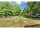 View of large, grassy backyard with wooden fence and shade trees at 745 Beaver Pond Trl, Fairburn, GA 30213
