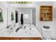 Bathroom featuring double sinks with a wooden cabinet and open wooden shelf at 745 Beaver Pond Trl, Fairburn, GA 30213