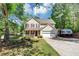 Inviting two-story home with a cozy front porch, a two car garage, and green lawn at 745 Beaver Pond Trl, Fairburn, GA 30213