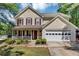 Charming two-story home with a welcoming front porch and manicured lawn at 745 Beaver Pond Trl, Fairburn, GA 30213
