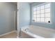 Bright bathroom showcases a luxurious soaking tub, ample natural light, and soothing blue walls at 2293 Baker Station Dr, Acworth, GA 30101