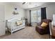Bedroom featuring a crib, chair, dresser, and natural light at 2293 Baker Station Dr, Acworth, GA 30101