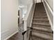 Carpeted staircase with wooden handrail, neutral walls, and view of the entry at 2293 Baker Station Dr, Acworth, GA 30101