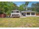 Back exterior showcasing a deck with a hot tub, a sunroom, and a large yard at 2710 Hayden Dr, East Point, GA 30344