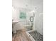 Bathroom featuring wood-look tile flooring and a glass enclosed shower with decorative accent tile at 2710 Hayden Dr, East Point, GA 30344