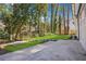 Backyard with lush green grass, mature trees, and a view of the rear of the home at 335 Amberidge Trl, Atlanta, GA 30328