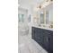 Bathroom featuring double sinks, marble floors, modern fixtures, and natural light from the window at 335 Amberidge Trl, Atlanta, GA 30328