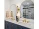 Bathroom featuring double sinks, marble floors, modern fixtures, and arched mirrors at 335 Amberidge Trl, Atlanta, GA 30328