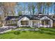 Charming, updated home with white brick, black trim, covered parking, and manicured lawn at 335 Amberidge Trl, Atlanta, GA 30328