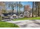 White brick home with black roof, black trim, covered parking, and mature trees at 335 Amberidge Trl, Atlanta, GA 30328