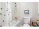 Bright bathroom featuring a shower-tub combo, toilet, and decorative shower curtain at 431 Shore Dr, Suwanee, GA 30024