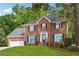 Beautiful two-story brick home with lush green lawn, attached garage, and traditional shutters at 431 Shore Dr, Suwanee, GA 30024